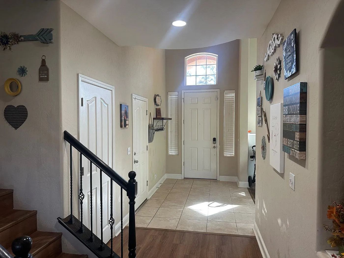 Entry with tile flooring and iron staircase