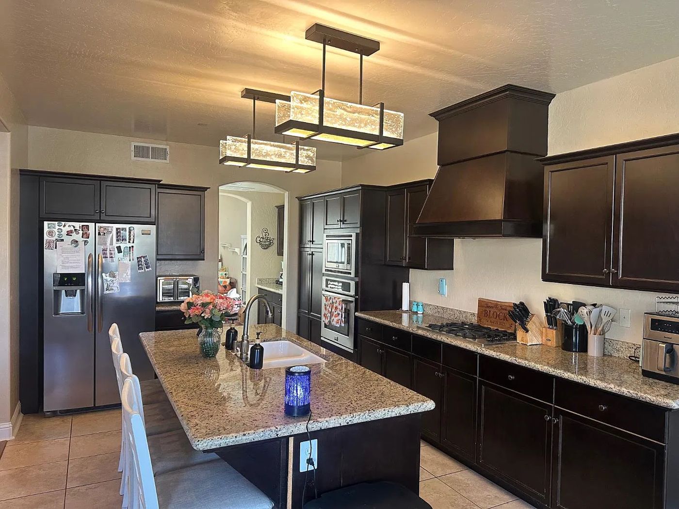 Kitchen with dark cabinetry, granite island and stainless appliances