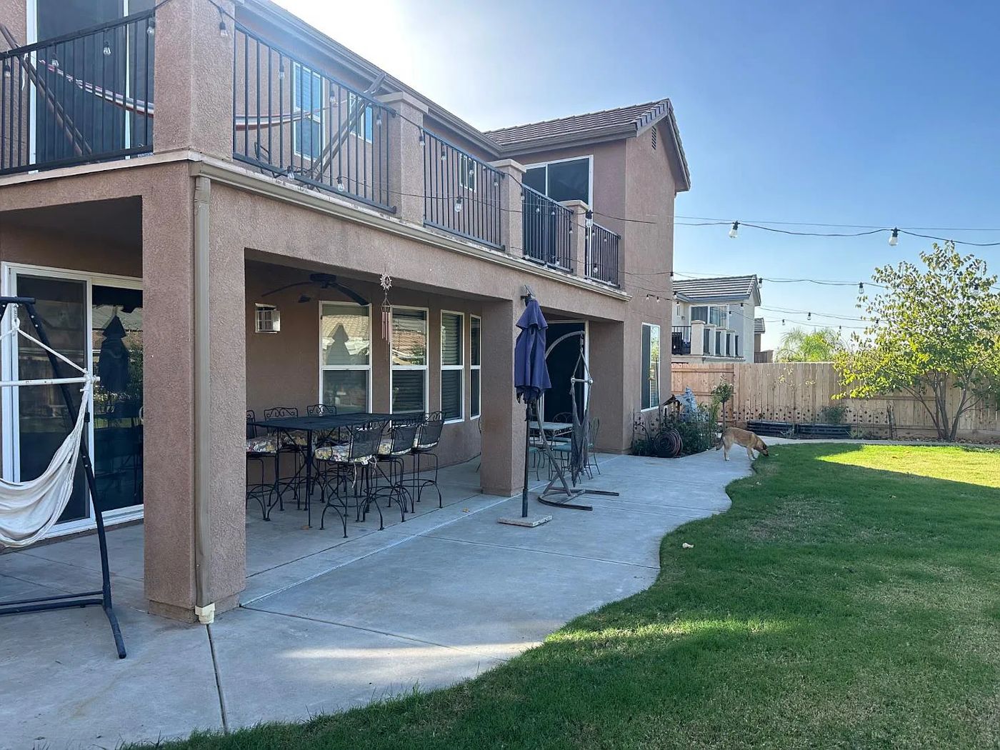 Covered patio with dining set beside the lawn